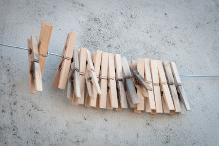Wooden peg on steel cable for laundry hanging. Housework outdoor