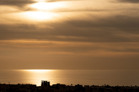 Dramatic beautiful sunset in the coast. Orange dramatic colours on cloudy sky. End of day. Sun on the horizonの写真素材