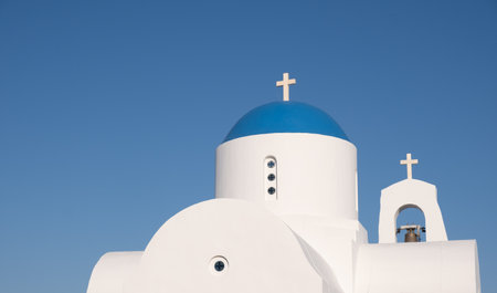 Traditional small christian orthodox church with belfry white and blue dome against cloudy sky.の写真素材