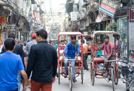 Bicycle taxi drivers transporting people in a traditional market street in Indiaのeditorial素材
