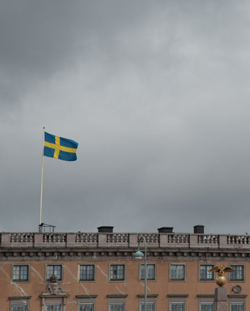 Swedish flag flying over buildings in helsinki finland on a cloudy dayの写真素材