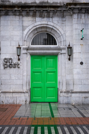 Green wooden door of an irish post office buildingの写真素材