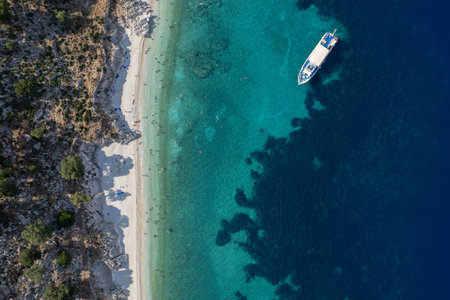 Drone Aerial view of tourists enjoying summer on a Greek isolated tropical beach with turquoise...