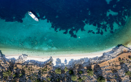 Tourists enjoying summer sunbathing and swimming on secluded beach drone aerial viewの写真素材