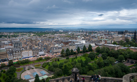 Tourists admiring edinburgh cityscape from castle on a cloudy dayのeditorial素材
