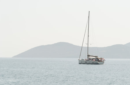 Sailboat with mast and open sails is sailing on a calm sea. Greek Islands, Ionian Seaの写真素材
