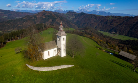 Drone view of st tomaz selca church standing on green hill in Slovenian countryside.の写真素材