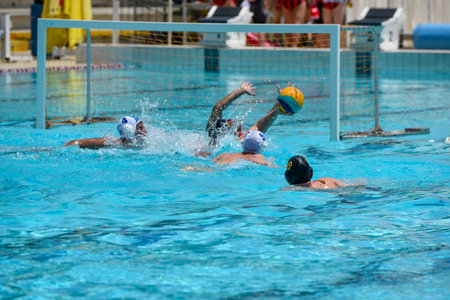 Athletes in swimming pool playing water polo. Aquatic sport. Championship competition.