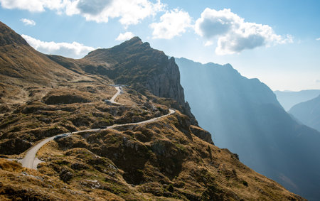 Winding mountain road leading to breathtaking alpine scenery. Mount mangart, Sloveniaの写真素材