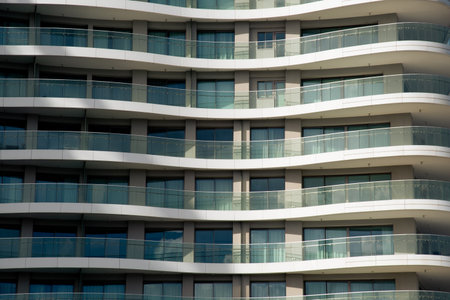 Repetitive balconies and windows create a mesmerizing pattern on a modern building facade