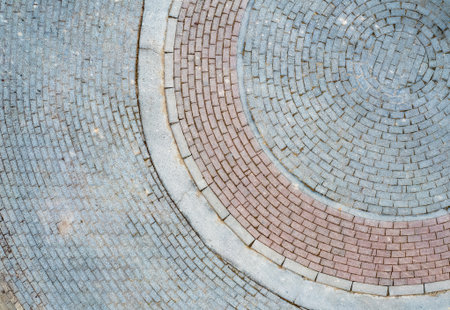 Cobblestones and bricks arranged in a circular pattern creating a visually appealing designの写真素材