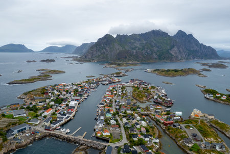 Drone aerial view of henningsaer, a picturesque fishing village nestled among the rugged mountains and serene waters of the lofoten islands in norwayの写真素材