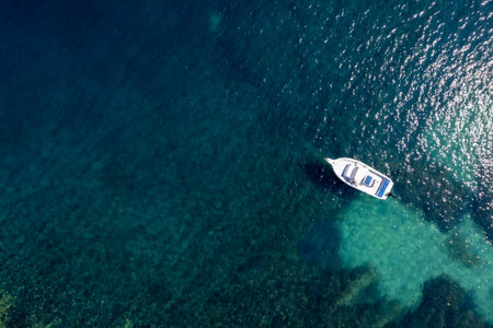 Drone aerial scenery of motorboat moored in the shallow sea. Calm blue turquoise waterの写真素材