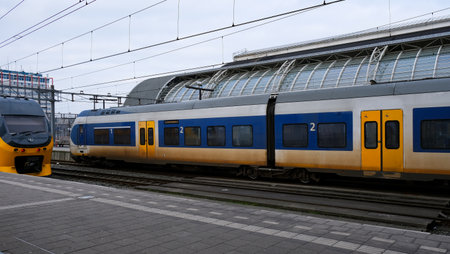 Multiple trains at the railway station, with one train in motion and another parked. urban transit...