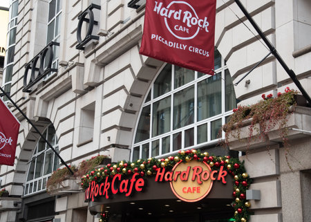 London, United Kingdom, November 24 2025: Hard rock cafe entrance adorned with festive christmas garlands and a red flag. Piccadilly Circus, Londonのeditorial素材