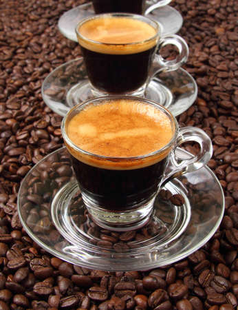 Espresso in a transparent cup on the background of coffee beansの写真素材