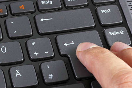 Close up of a finger pressing enterの写真素材