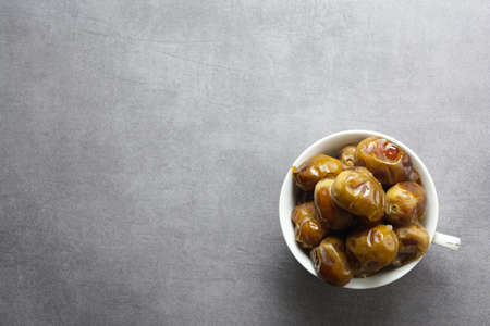 a sweet date dish set in a white glass on a fake cement backgroundの写真素材