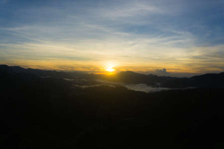 Scenic view of a sunrise over foggy mountain rangeの写真素材