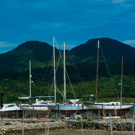 Yachts on the beach with mountains as background