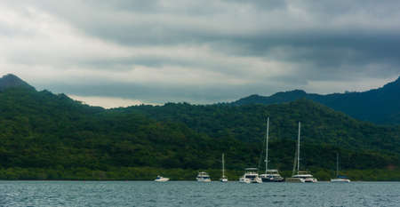 Yachts on the beach with mountains as backgroundの写真素材