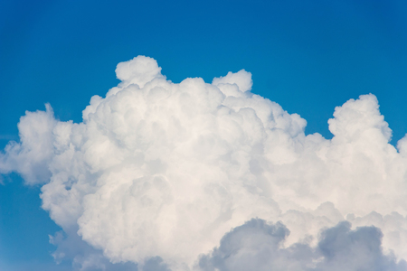 Clouds that look like fluff. The color contrasts with the dark sky background.の写真素材