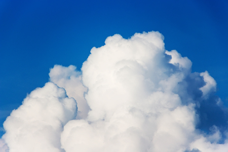 Clouds that look like fluff. The color contrasts with the dark sky background.の写真素材
