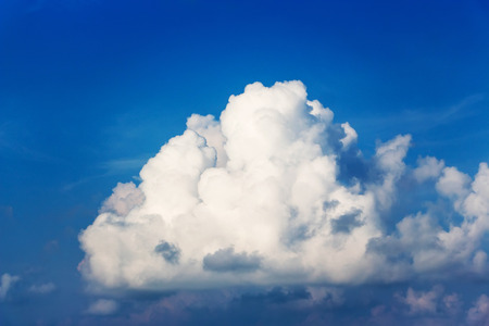 Clouds that look like fluff. The color contrasts with the dark sky background.の写真素材