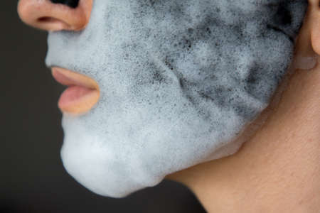 Isolated girl with cleansing mask on the face.の写真素材