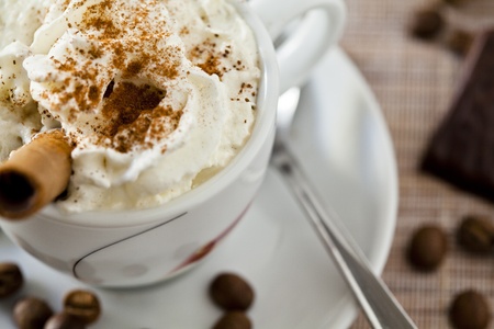 Photograph of a coffee cup with whipped cream and chocolate candyの写真素材