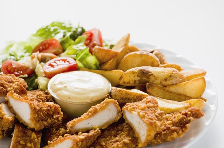 Photograph of Tasty meal with Chicken Nuggets Potatoes and Saladの写真素材