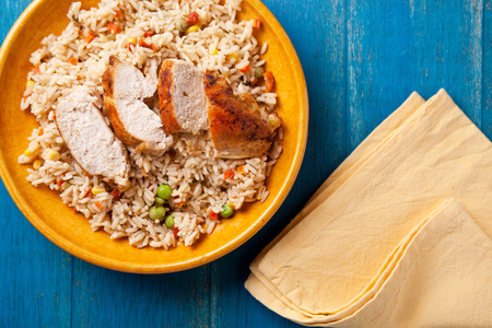 Close up photograph of a meal of chicken and rice with vegetablesの写真素材
