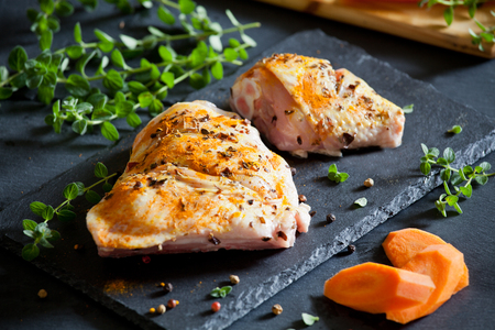 Raw chicken leg with spices and vegetablesの写真素材