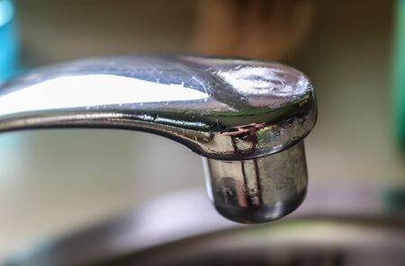 Running water out of a water tap in a metallic kitchen sinkの写真素材