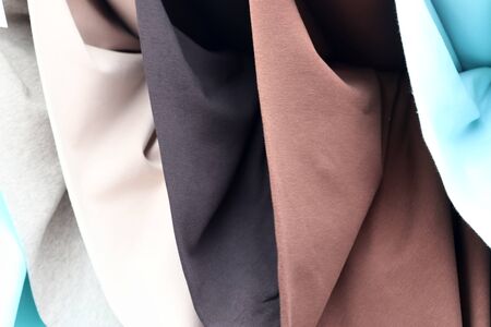Close up view on colorful hanging and folded fabric textures and textiles in high resolution found on a fabrics marketの写真素材