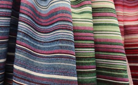 Close up view on colorful hanging and folded fabric textures and textiles in high resolution found...