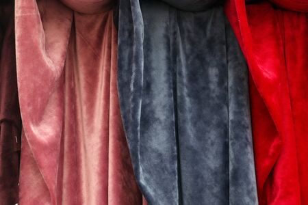 Close up view on colorful hanging and folded fabric textures and textiles in high resolution found on a fabrics marketの写真素材