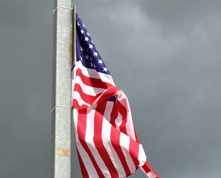 Close up view at a national USA flag moving in heavy windの写真素材