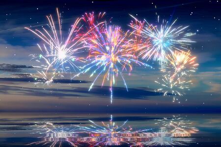Beautiful happy new year fireworks in the sky with reflections on waterの写真素材