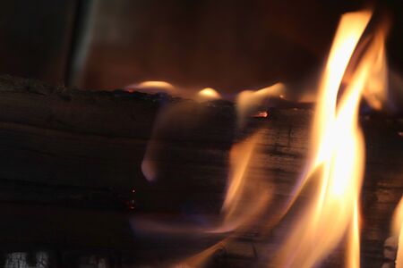 Close up on a crackling warm camp fire burning with red and orange flames
