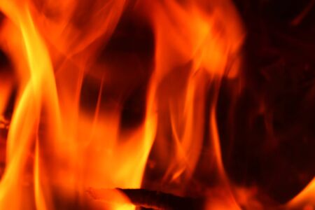 Close up on a crackling warm camp fire burning with red and orange flames