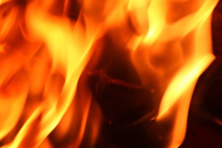 Close up on a crackling warm camp fire burning with red and orange flames