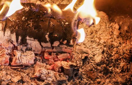Close up on a crackling warm camp fire burning with red and orange flamesの写真素材