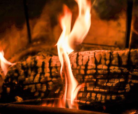 Close up on a crackling warm camp fire burning with red and orange flamesの写真素材