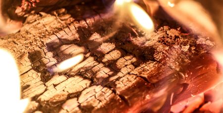 Close up on a crackling warm camp fire burning with red and orange flames