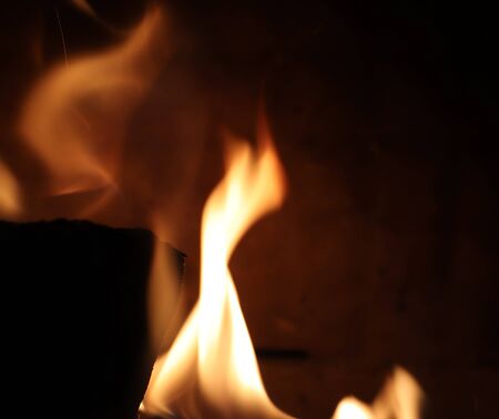 Close up on a crackling warm camp fire burning with red and orange flames