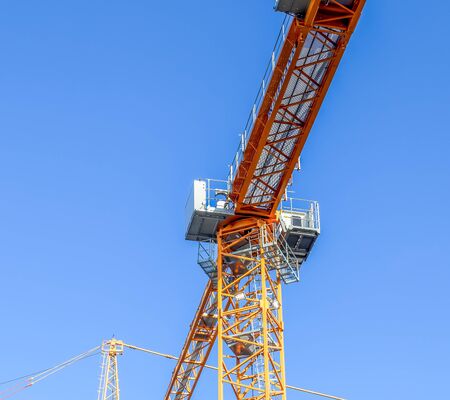 Big yellow cranes at a construction site in Kiel Germany on a sunny day with a clear blue sky
