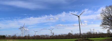 View on alternative energy windmills in a windpark in northern germany in front of a blue sky