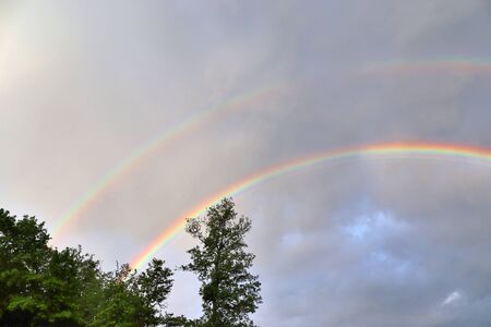 Stunning natural double rainbows plus supernumerary bows seen at a lake in northern germanyの写真素材