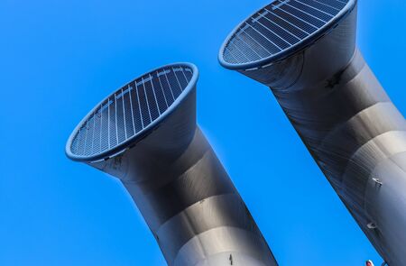 Industrial pipes made of steel in front of a blue sky